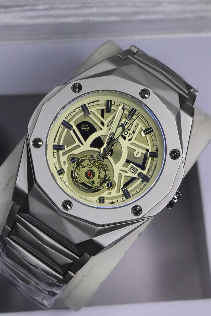 Luxury watch with a metallic case and visible mechanical components on a gray background