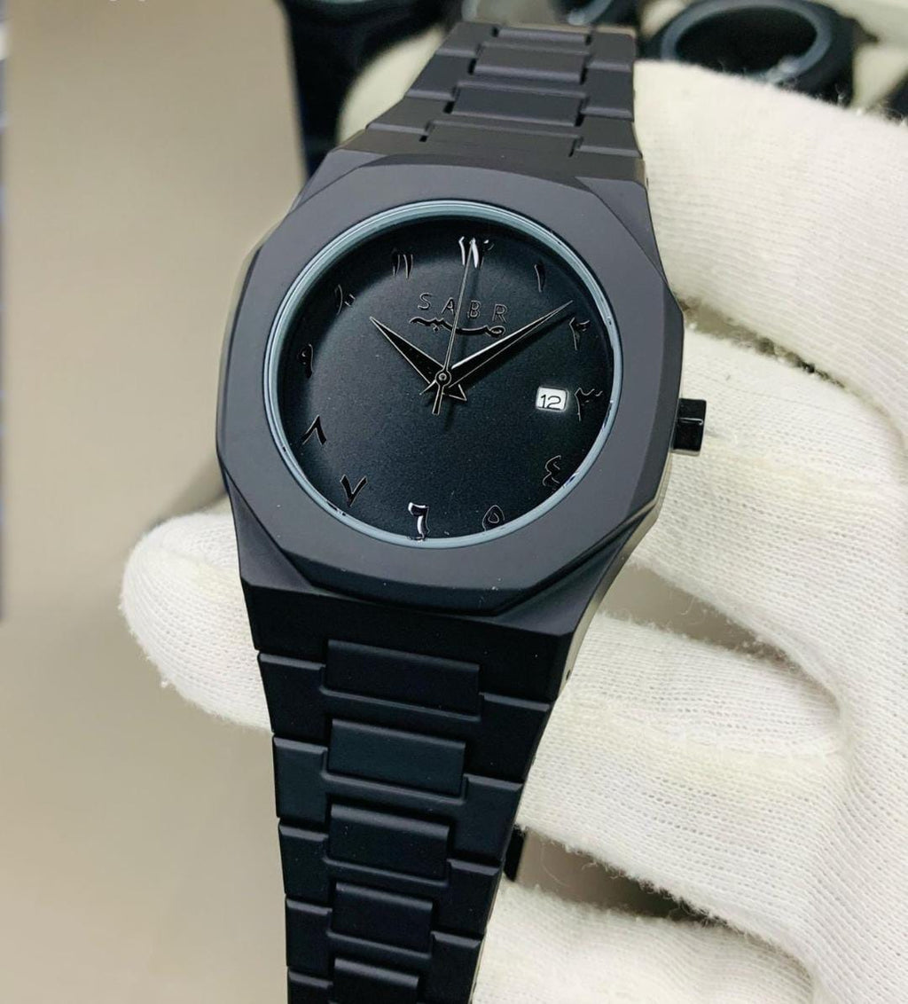 Black wristwatch with a textured strap on a white surface
