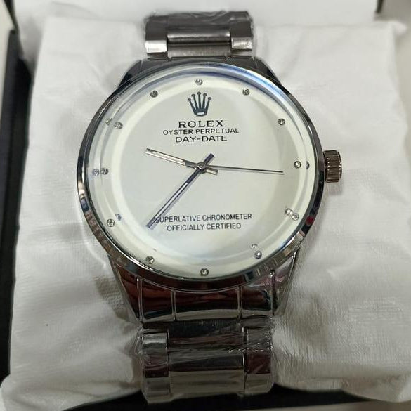 Silver Rolex watch with a white face on a white cloth background