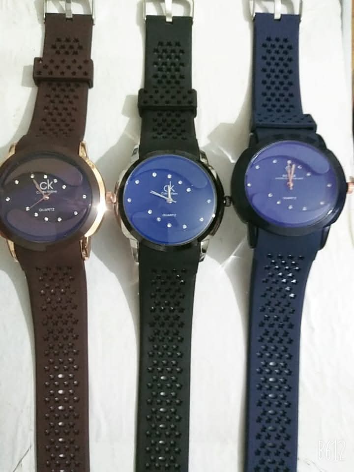 Three watches with different colored straps on a white background