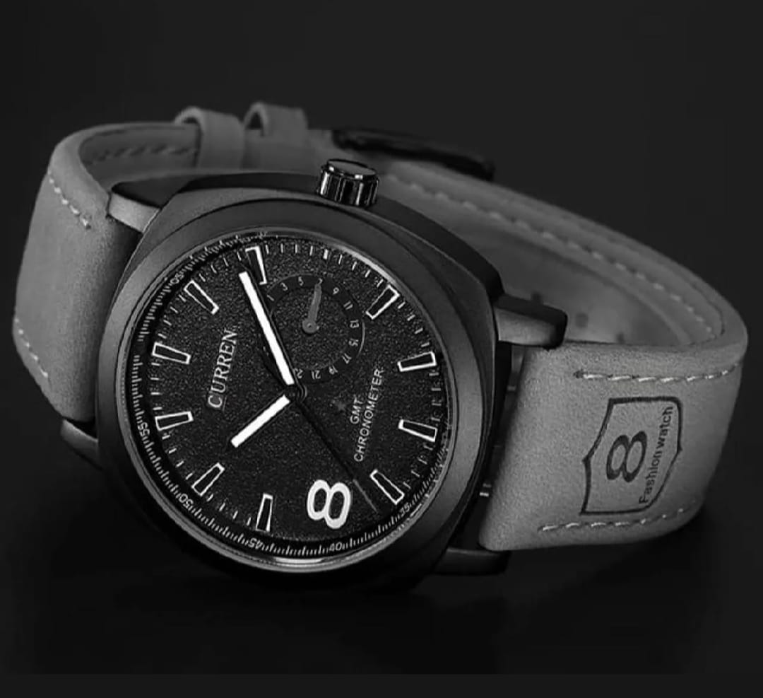 Wristwatch with black dial and gray leather strap on a dark background
