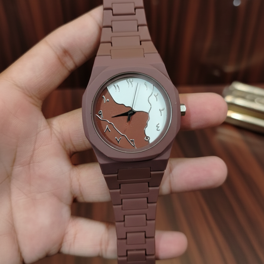 Brown watch with a unique face held in a hand against a wooden background
