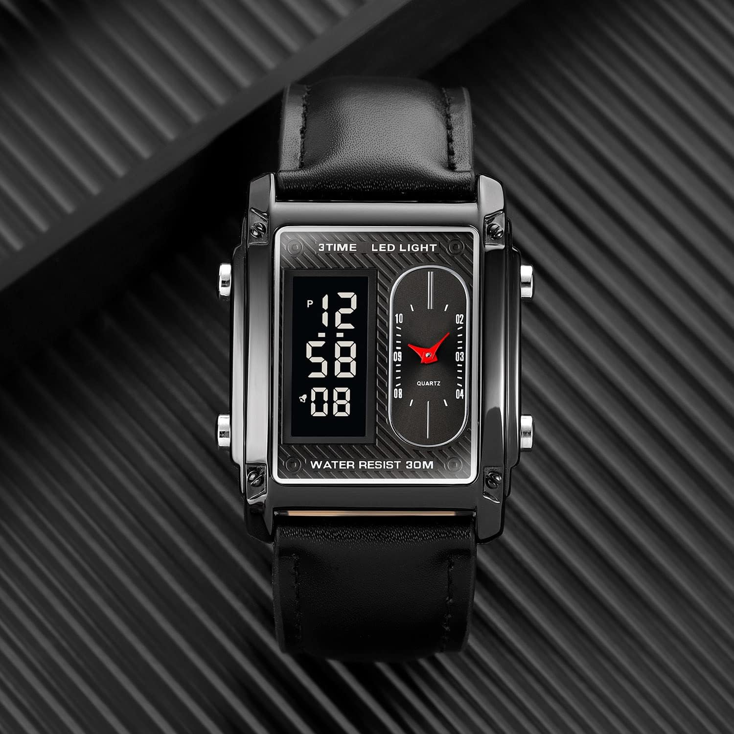 Black digital watch with a rectangular display on a black textured background