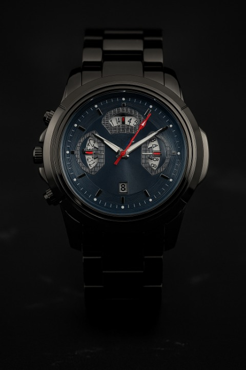 Black wristwatch with a detailed face on a dark background