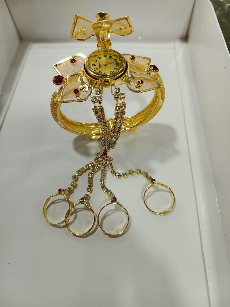 Gold jewelry set with a brooch, bracelet, and rings on a white background