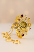 Gold owl-shaped watch with decorative elements on a beige background