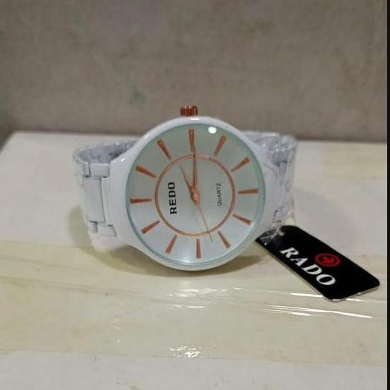 White Rado watch with orange accents on a light surface